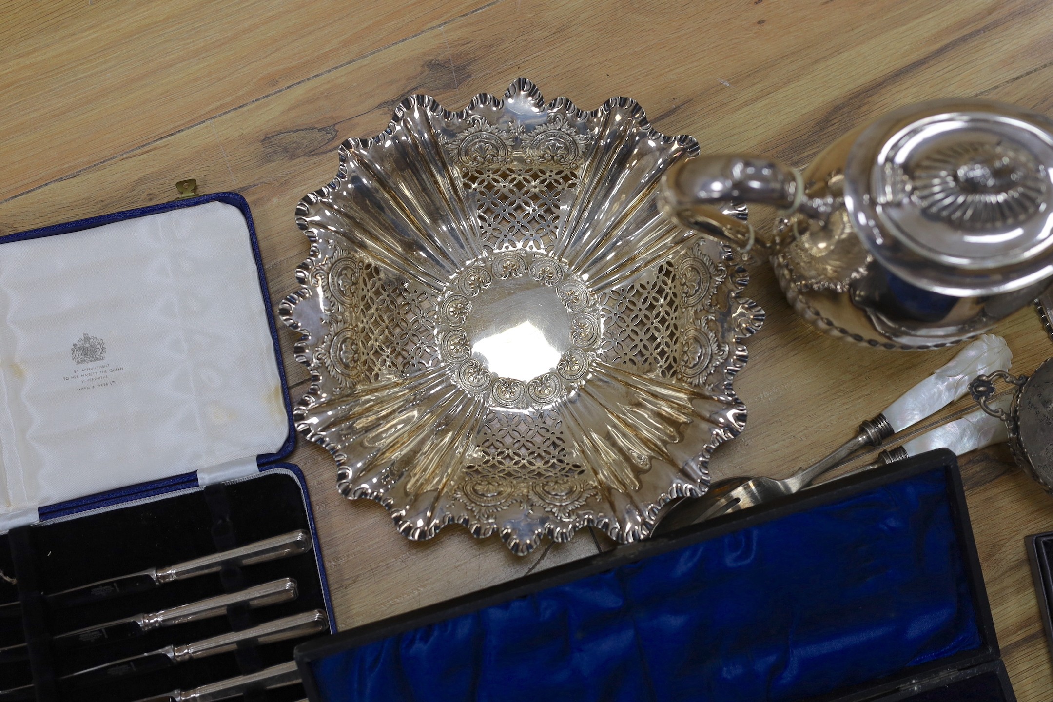 A cast white metal bowl and a collectio of plated items including a hot water pot, meat cover, cased flatware, etc.